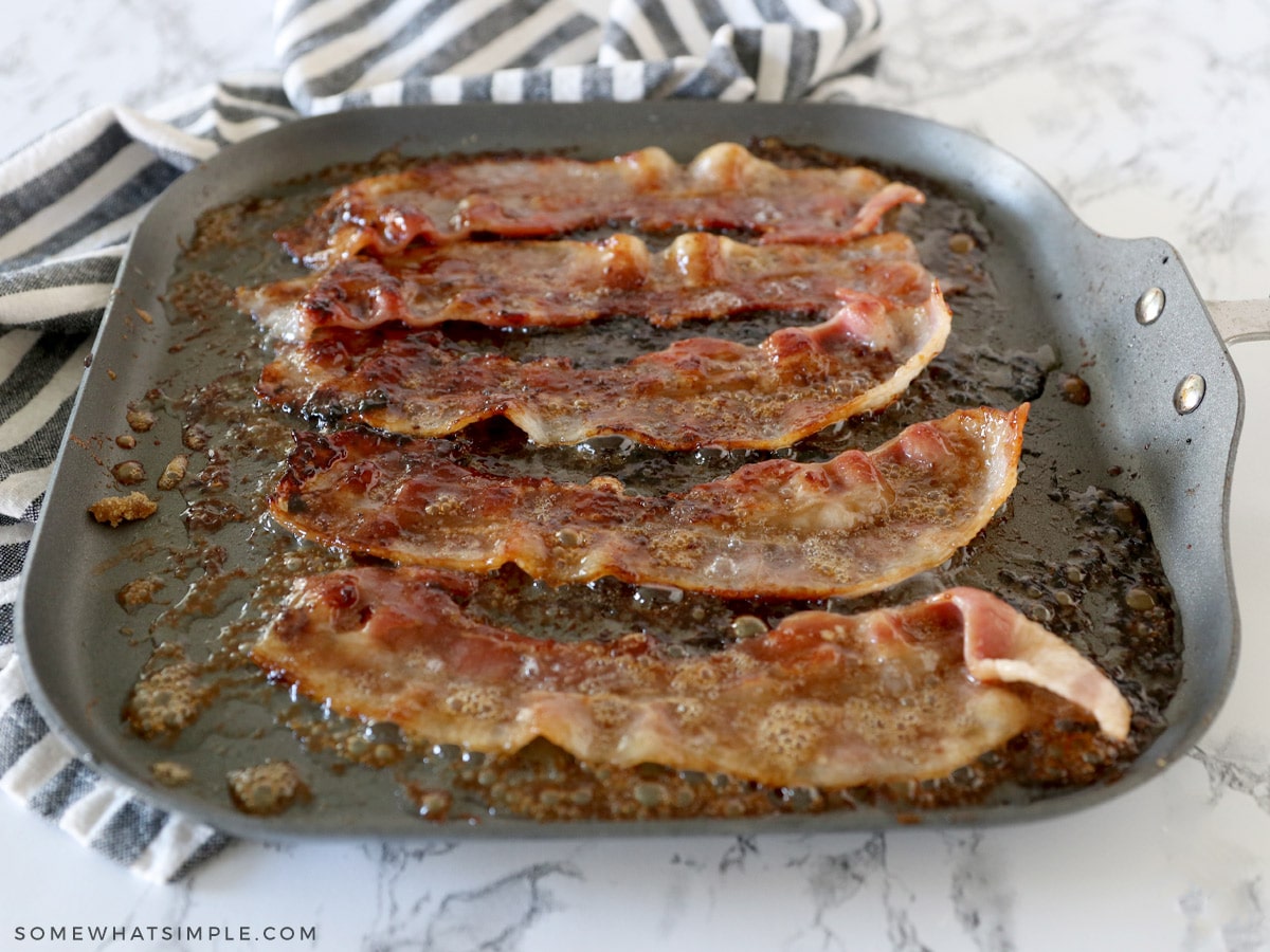 flipped candied bacon cooking on a skillet