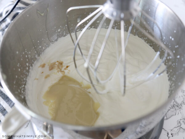 adding condensed milk to a mixing bowl of whipping cream