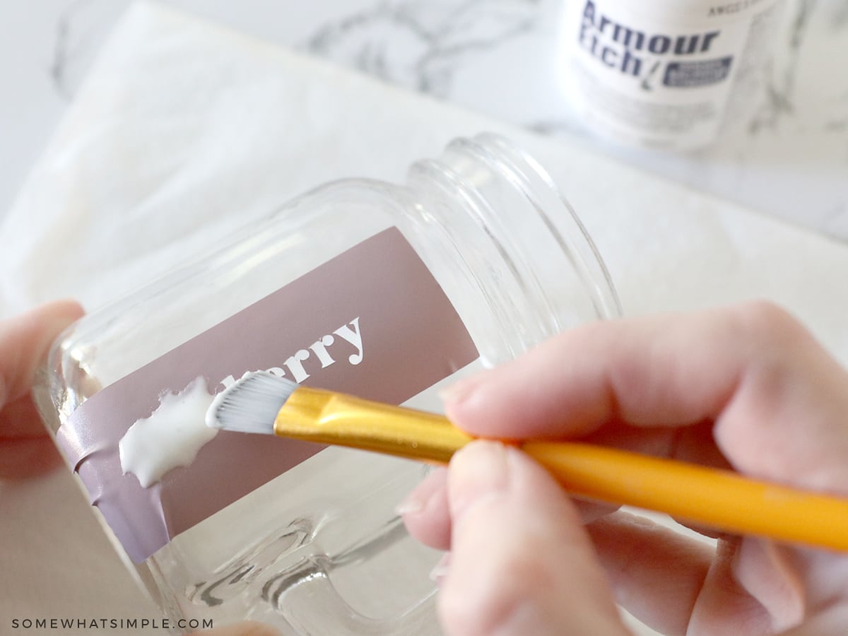 adding vinyl labels to a jar then spreading etching cream over the glass