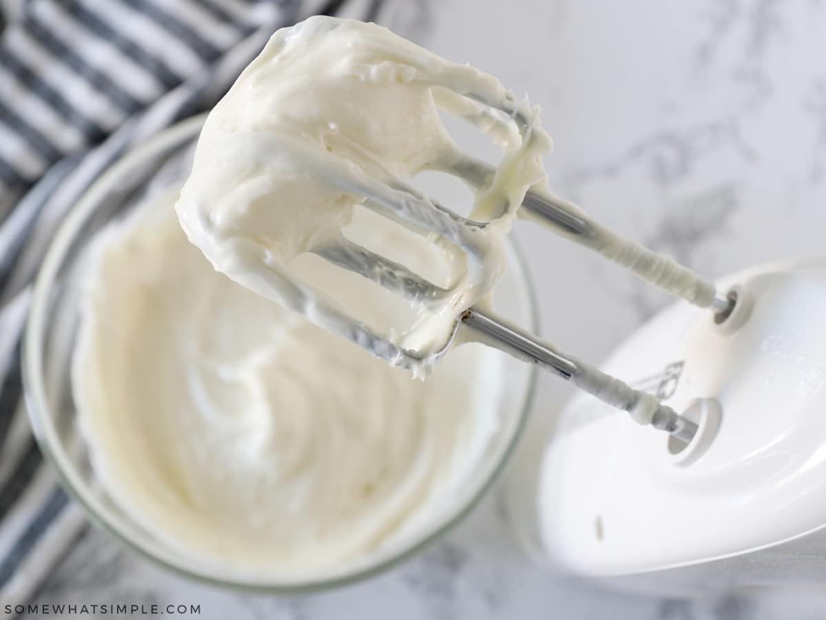 mixing cream cheese frosting with an electric beater