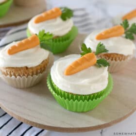 carrot cake cupcakes on a wood platter