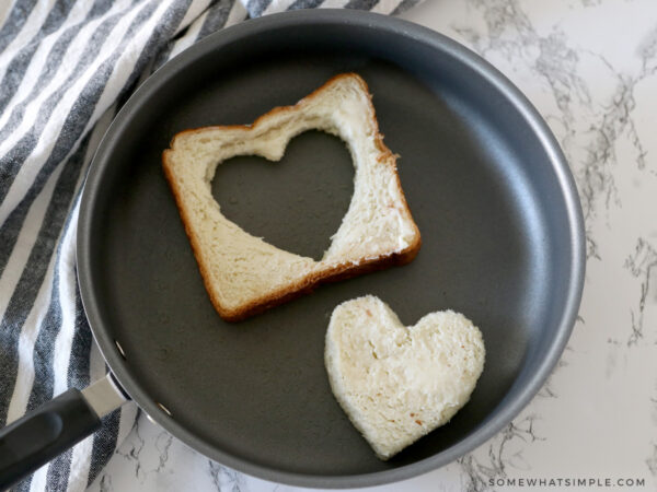 toasting one side of buttered bread cut into a heart