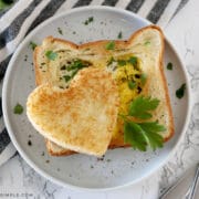 heart shaped eggs in toast plated on a white plate