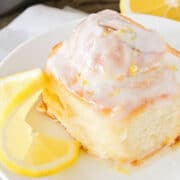 plated lemon sweet roll with a lemon slice next to it