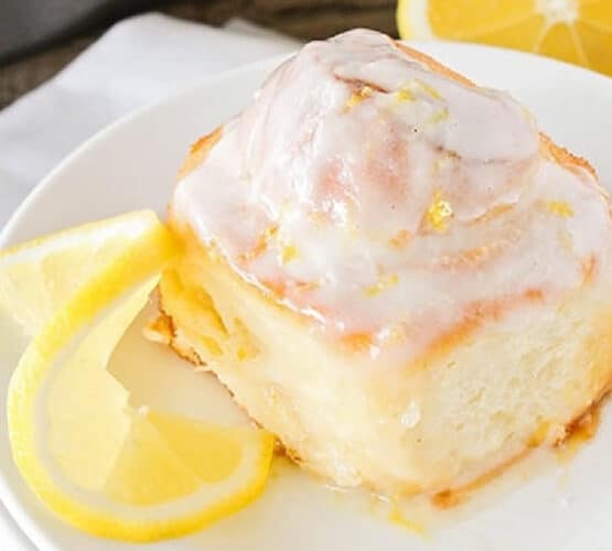 plated lemon sweet roll with a lemon slice next to it
