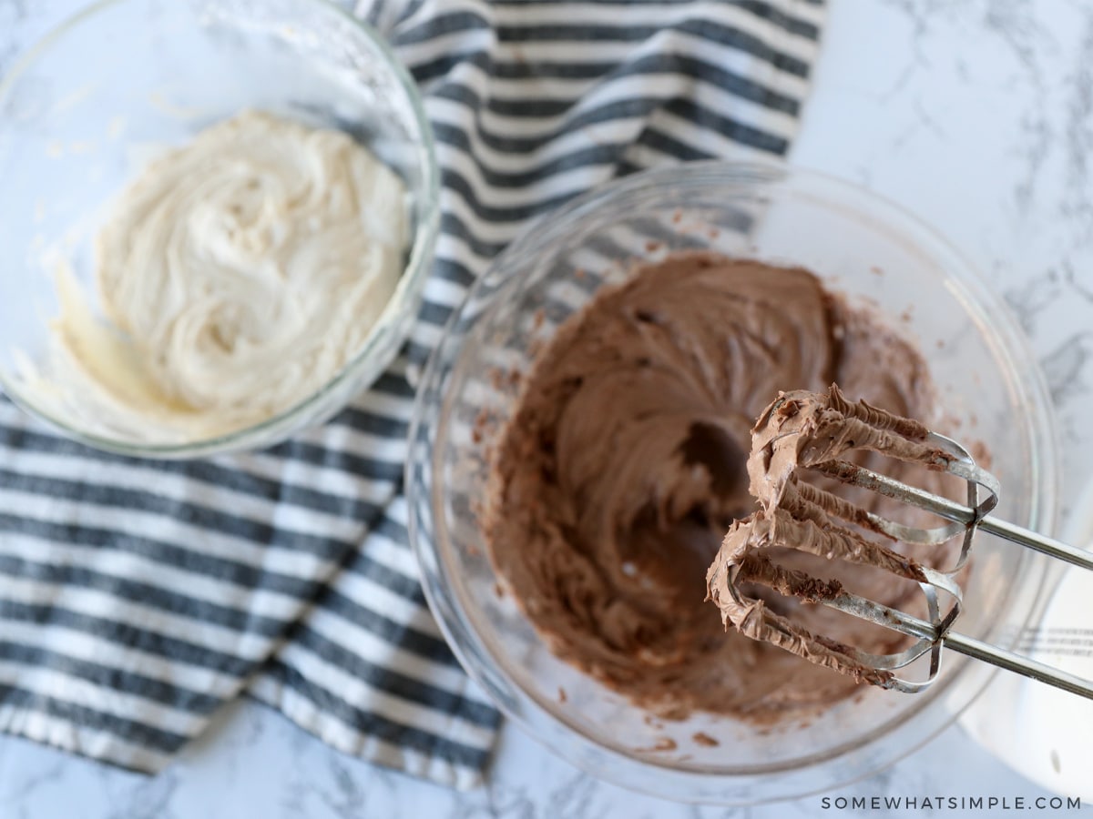 making chocolate buttercream frosting in a glass bowl