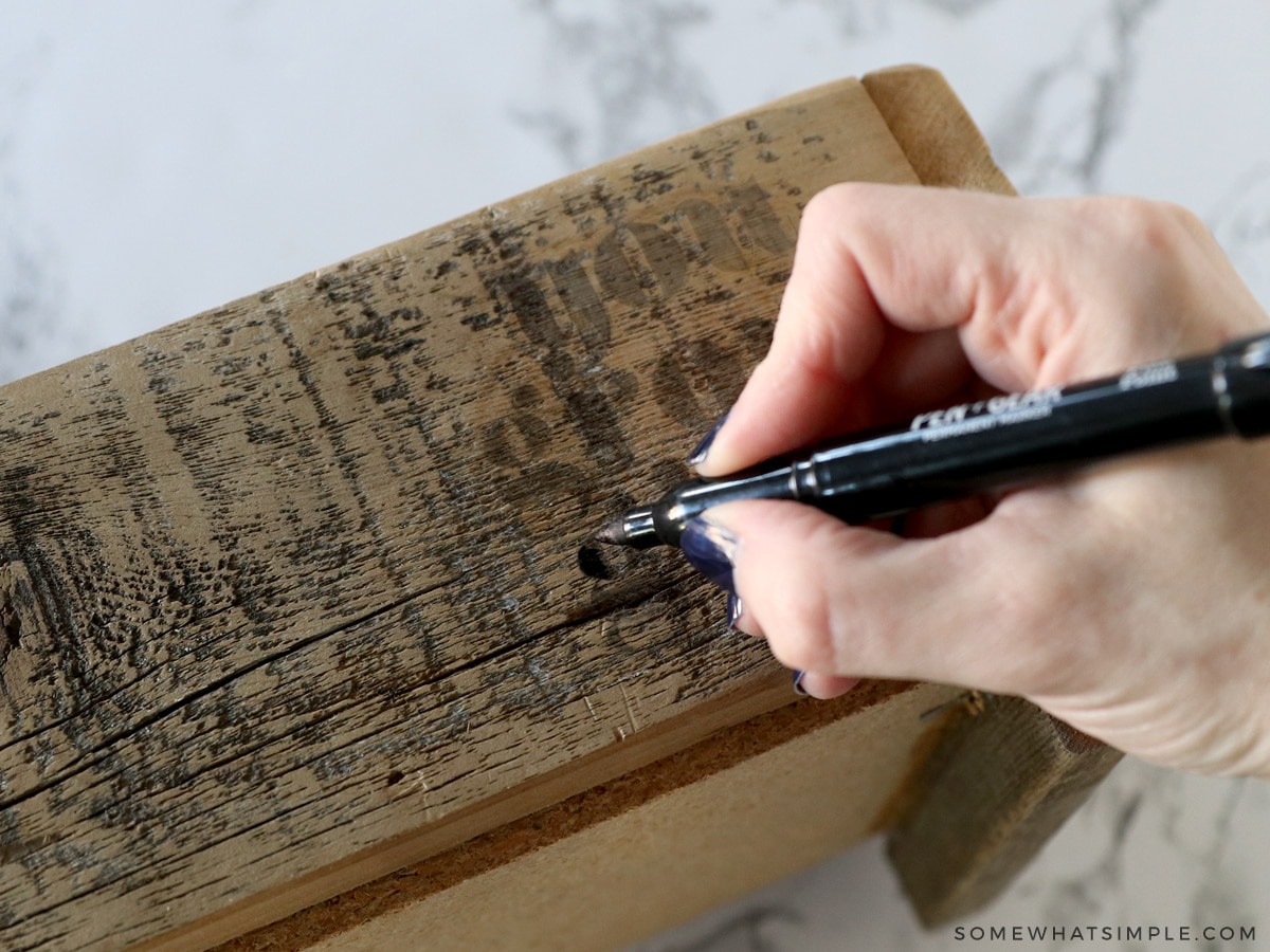 tracing the design onto a wood planter