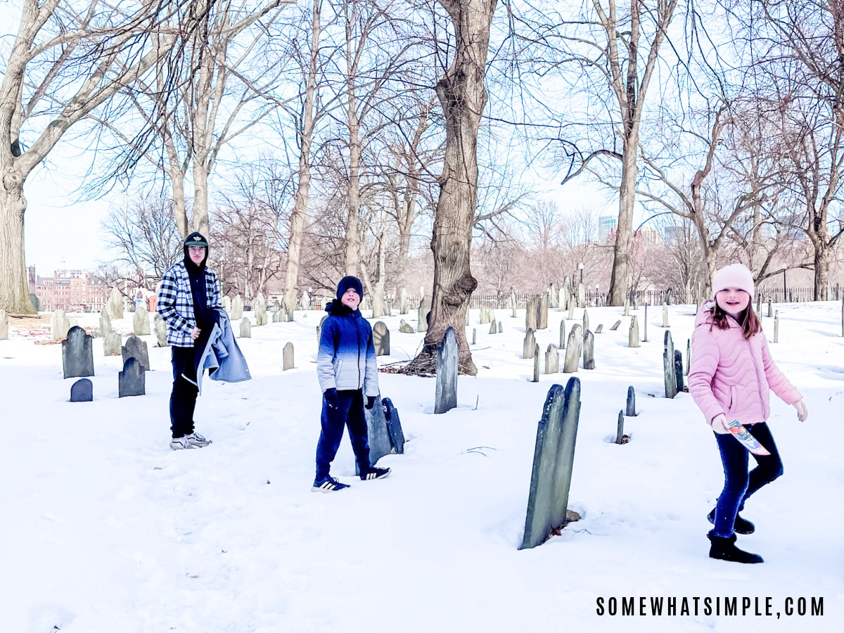 kids playing in a snowy graveyard