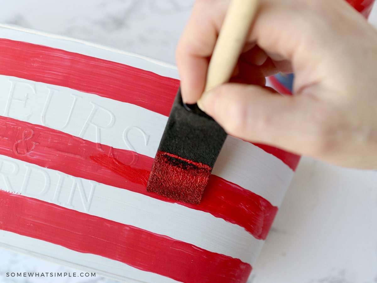 painting red and white stripes on a planter