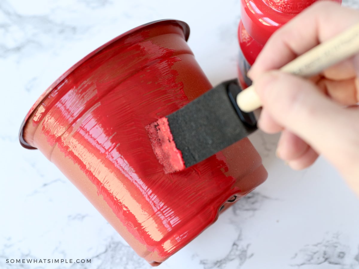 painting plastic pots to hold cutlery and paper goods