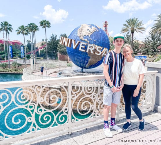 mom and son standing in front of the universal spinning globe