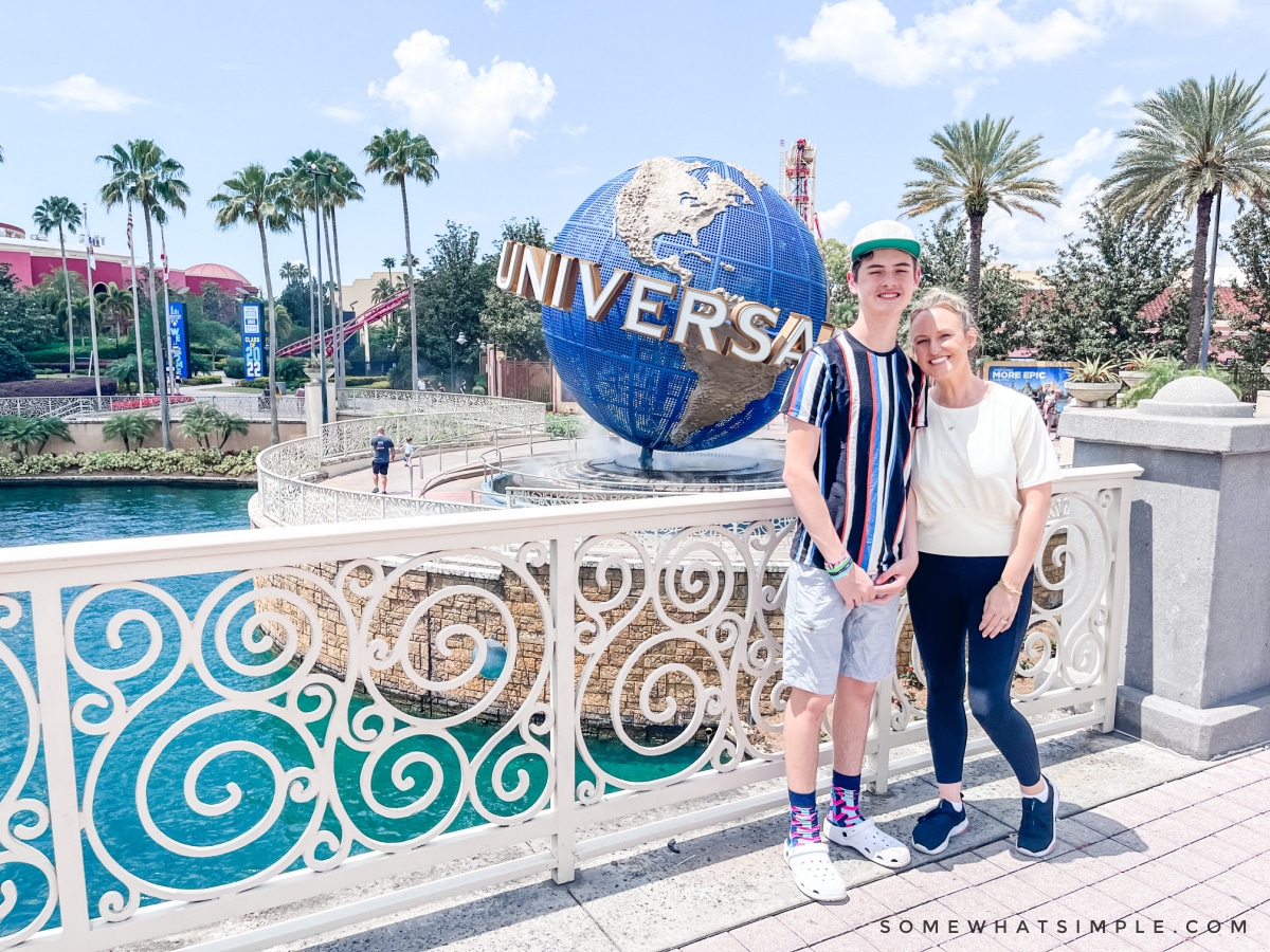 mom and son standing in front of the universal spinning globe