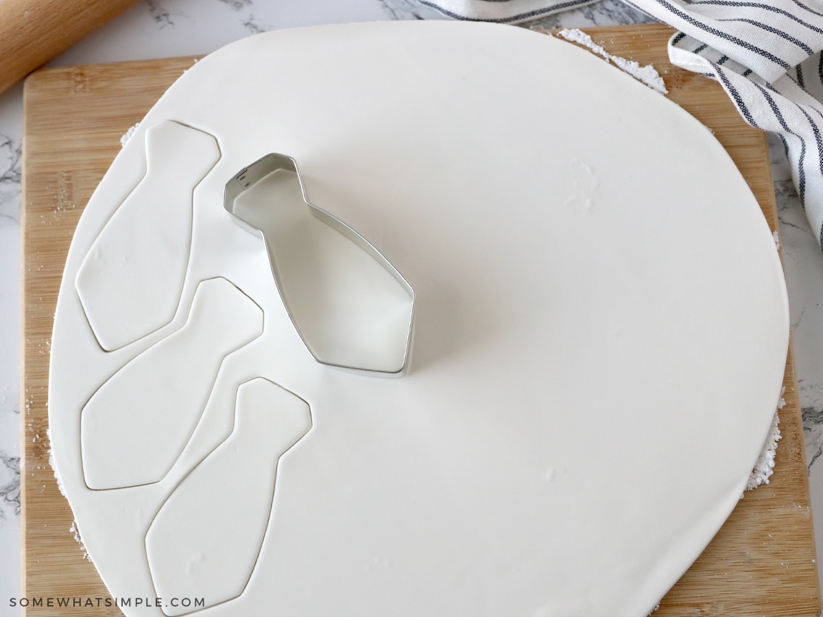 cutting out fondant in the shape of a necktie