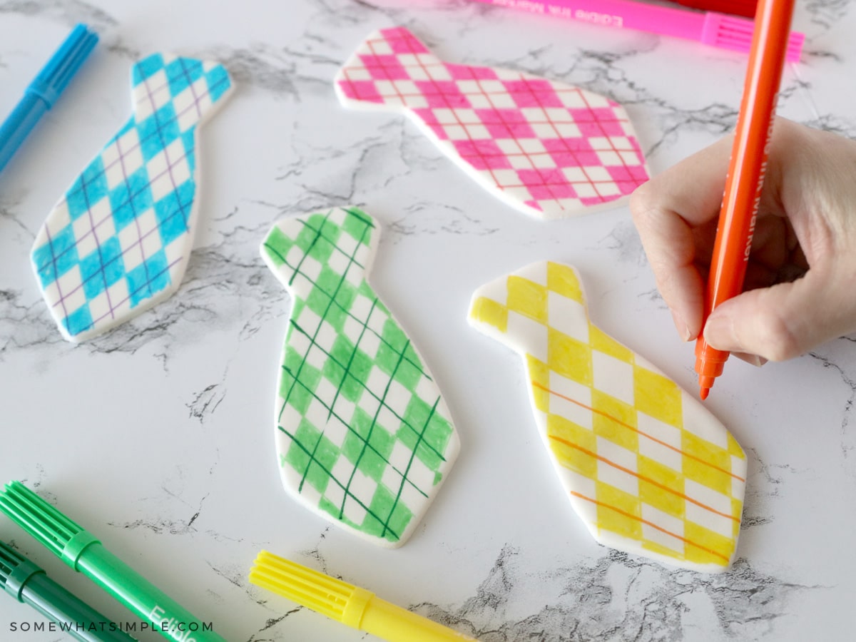 decorating fondant in the shape of ties with edible markers