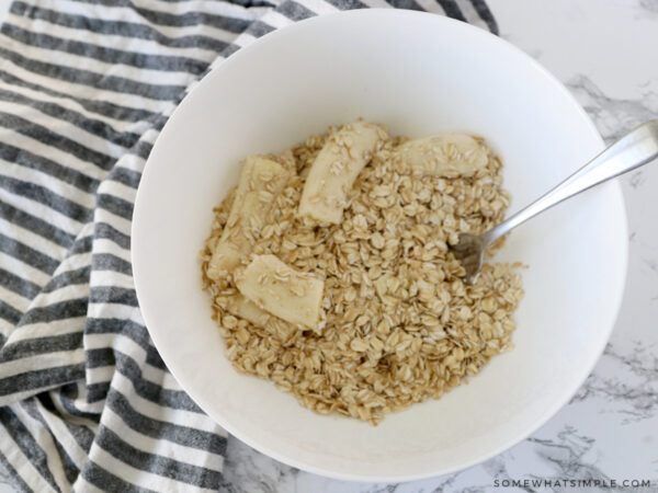 mashing bananas in a bowl of dried oatmeal