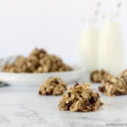 banana oatmeal cookies on a counter with milk in the background