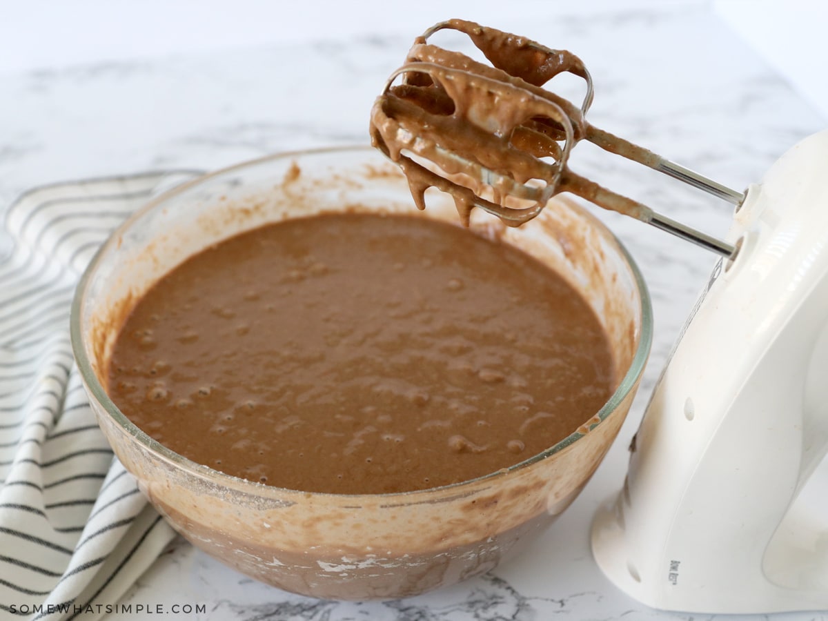 adding wet ingredients to dry ingredients in a glass bowl