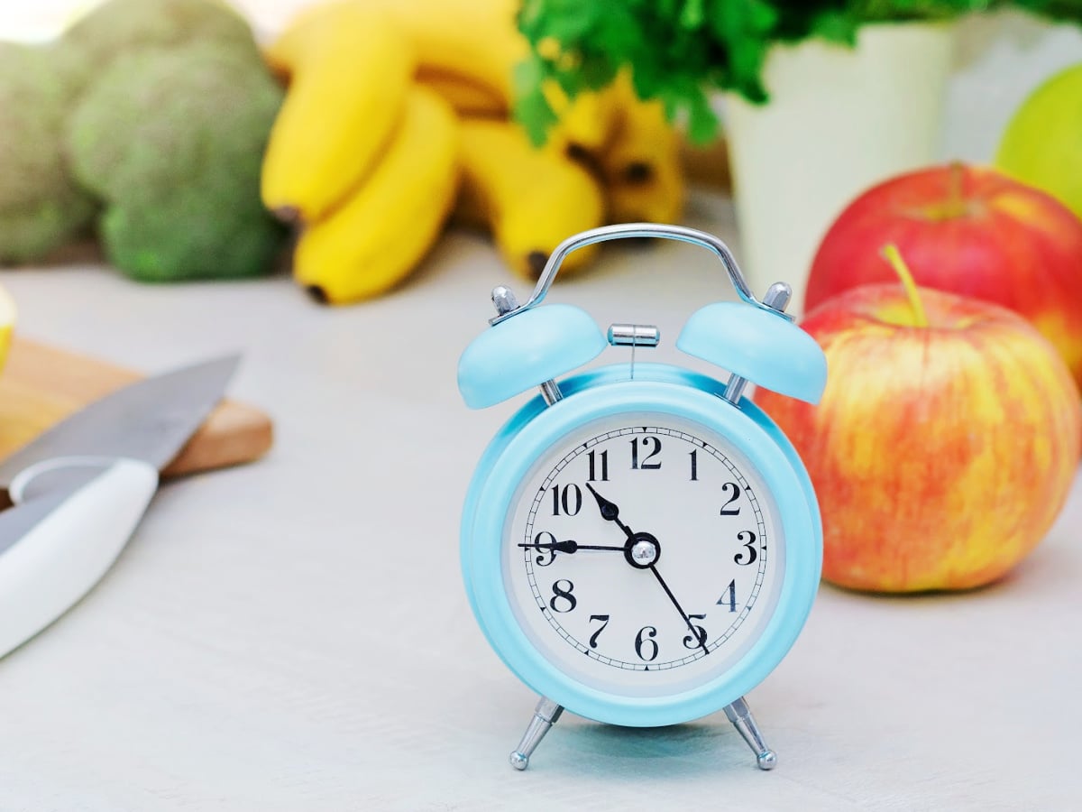 blue clock on a counter surround by snacks