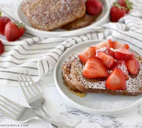plated zucchini bread french toast with strawberries and whipped cream