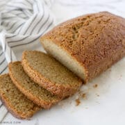 sliced zucchini bread on the counter next to fresh zucchini