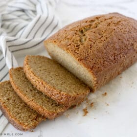 sliced zucchini bread on the counter next to fresh zucchini