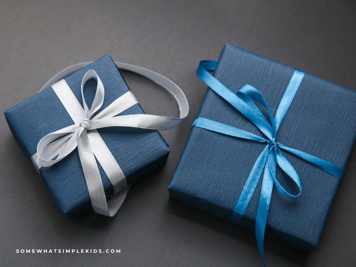 two gifts wrapped in blue wrapping paper on a dark gray background