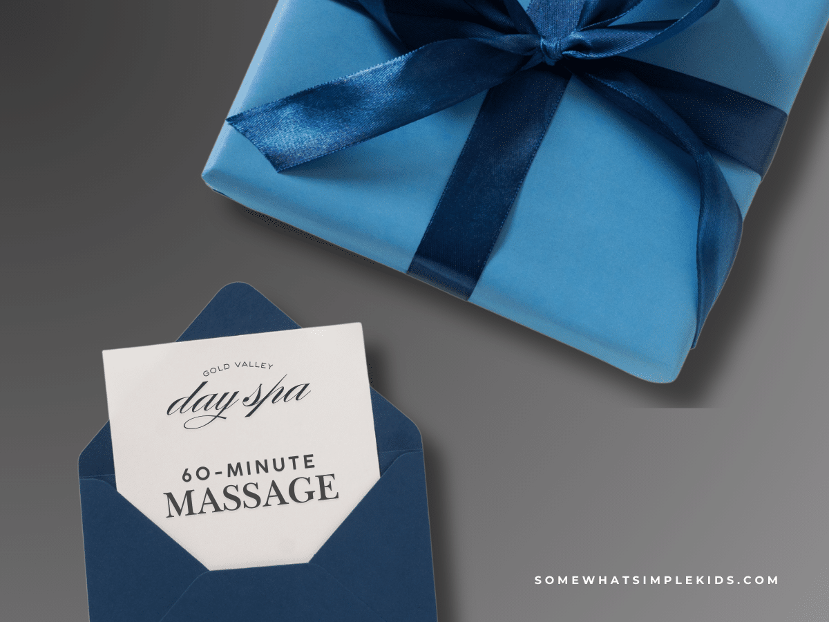 a wrapped gift next to a card opened showing a massage gift card