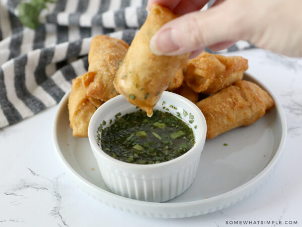 dipping an egg roll in chili lime sauce