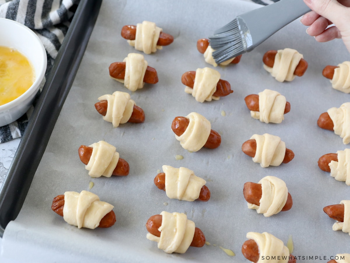 brushing pigs in a blanket with an egg wash