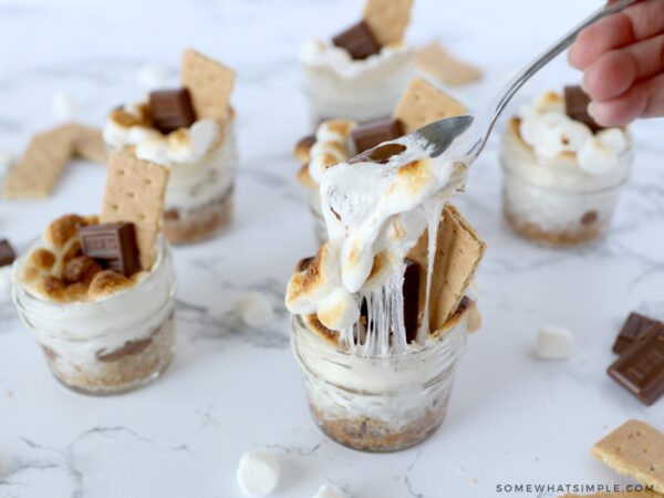 jars of smores, one with a spoon pulling out melty marshmallows