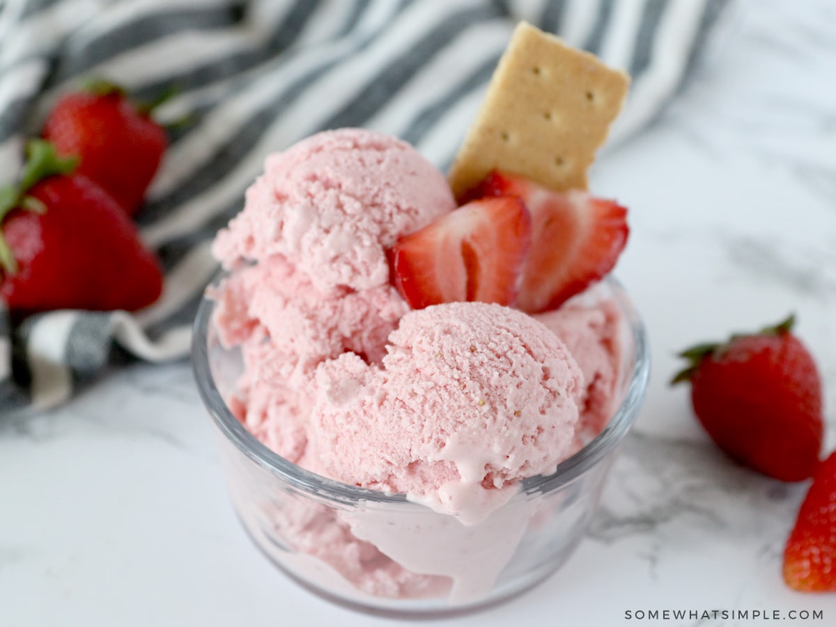 strawberry frozen yogurt with sliced strawberries and a graham cracker on top