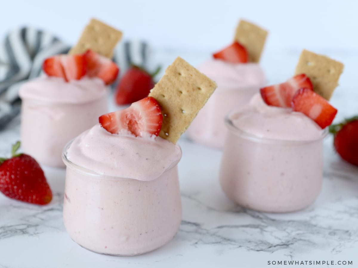 4 frozen yogurt cups with strawberries and graham crackers