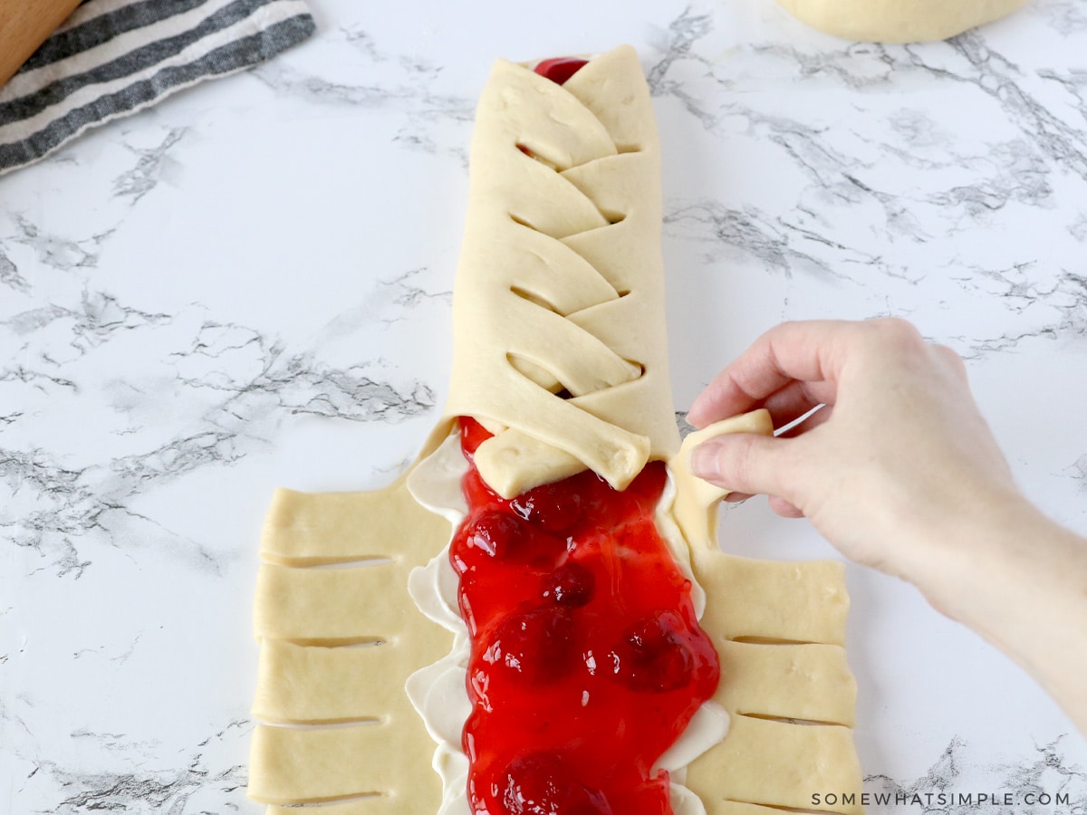 braiding a loaf of strawberry cream cheese bread