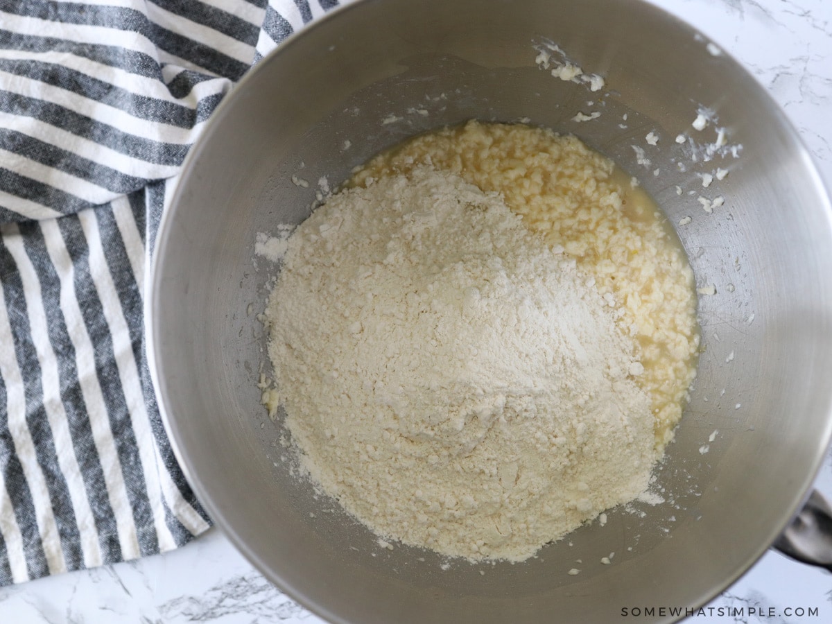 adding flour to a mixing bowl