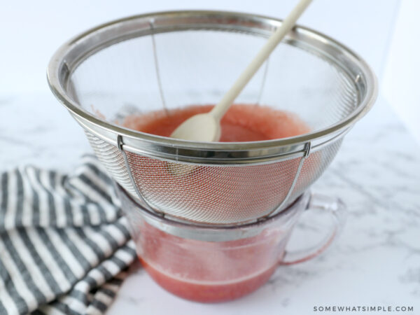 straining watermelon flesh to get watermelon juice