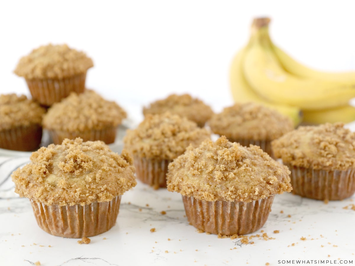 banana crumb muffins on a white counter with bananas in the background
