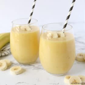 2 glasses filled with a banana smoothie