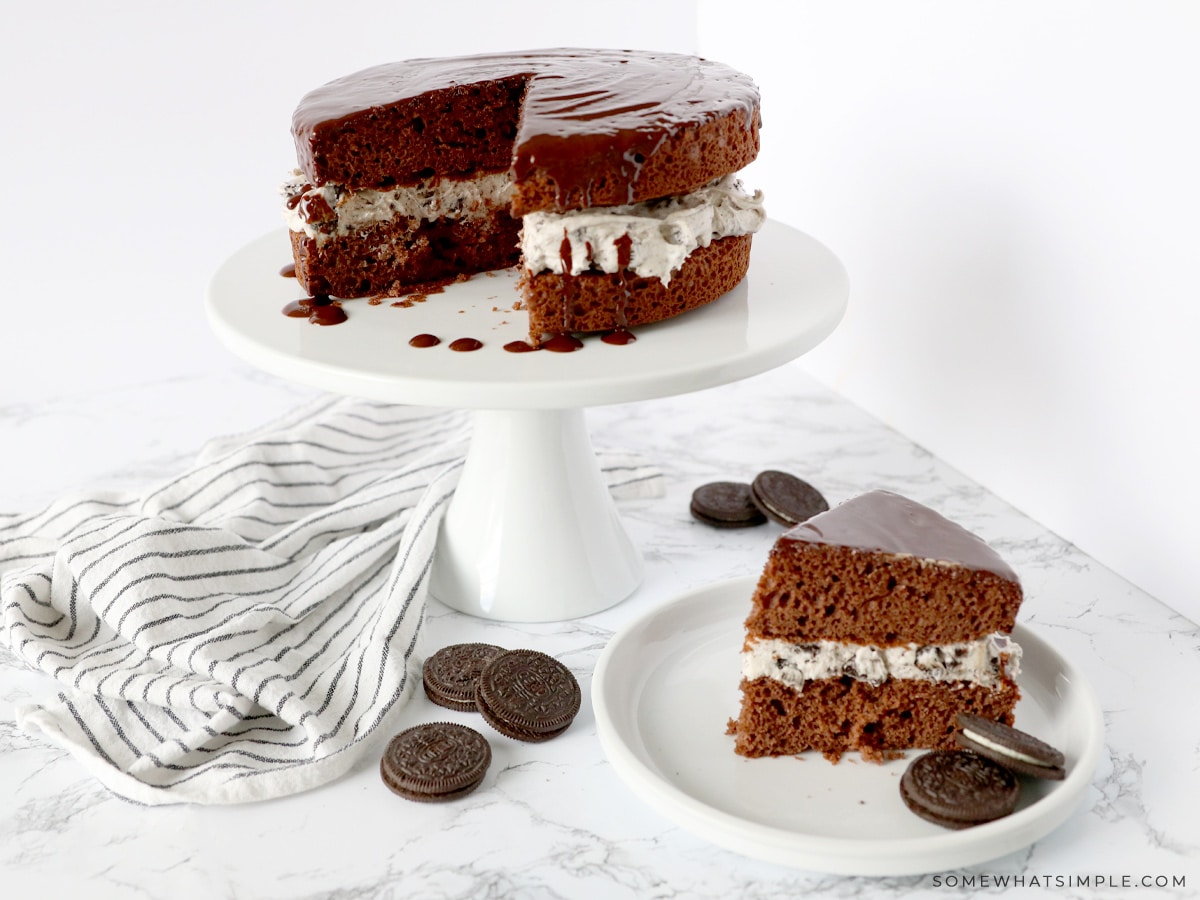 chocolate cake sliced on a serving plate with the rest of the cake in the background on a platter