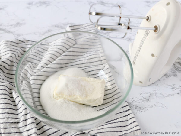 cream cheese and sugar in a glass mixing bowl