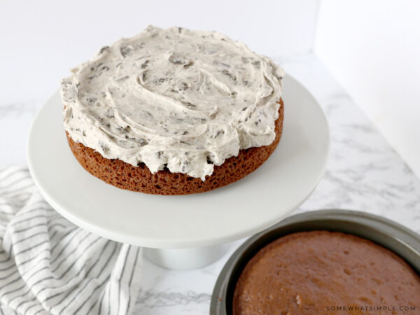 adding oreo frosting to a chocolate cake