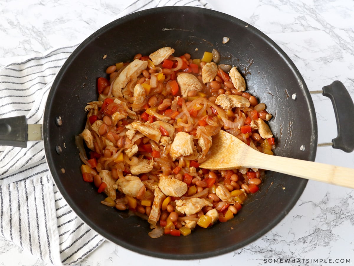 adding sauce to chicken and vegetable mixture