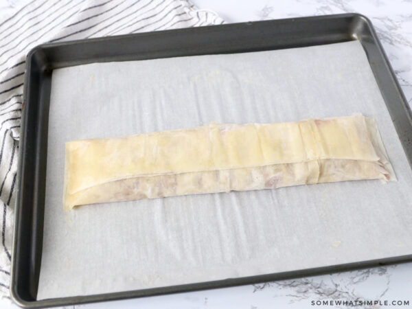 folding the last side of filo dough over a cherry pastry