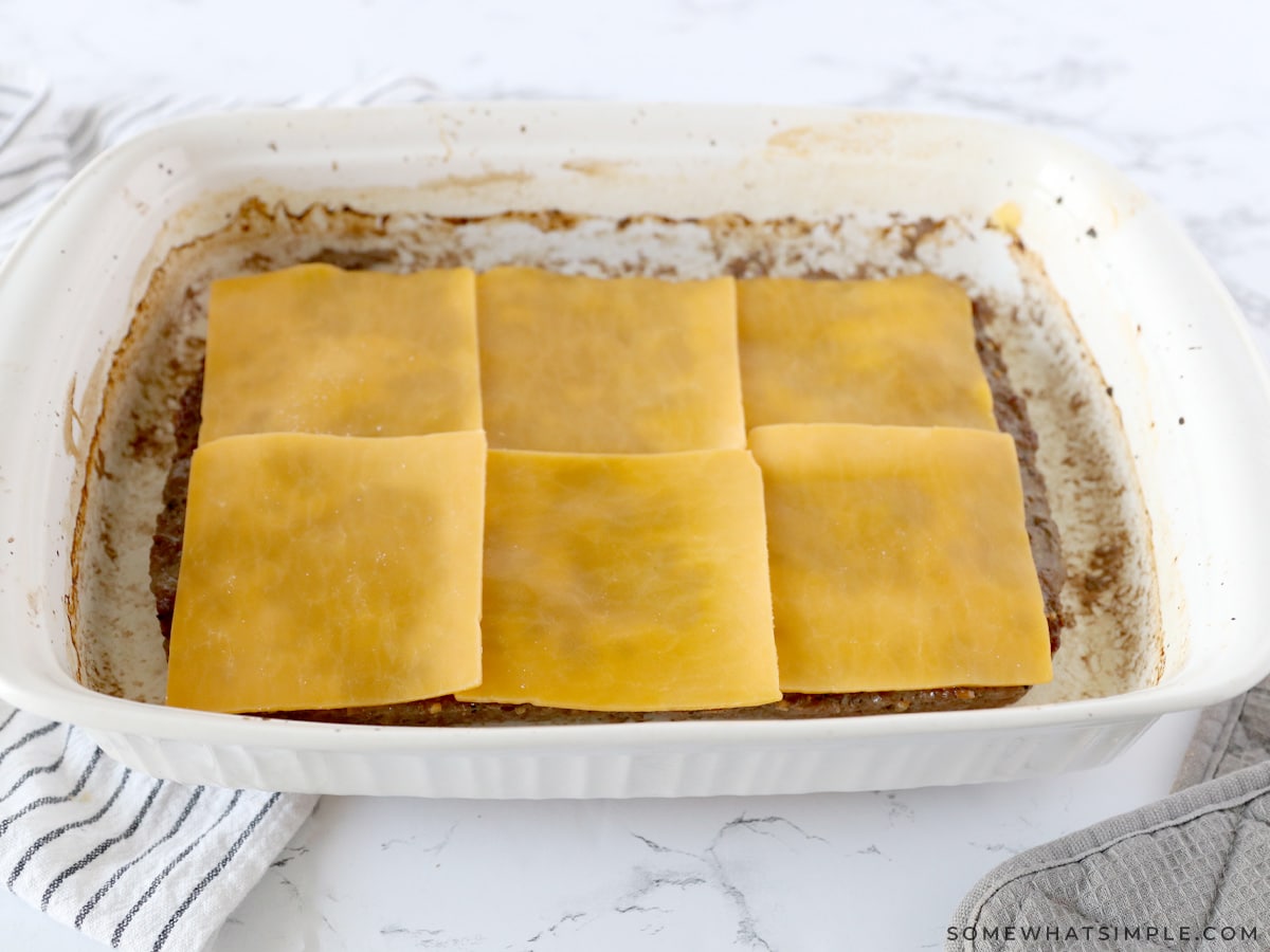 adding cheese to the top of cooked beef