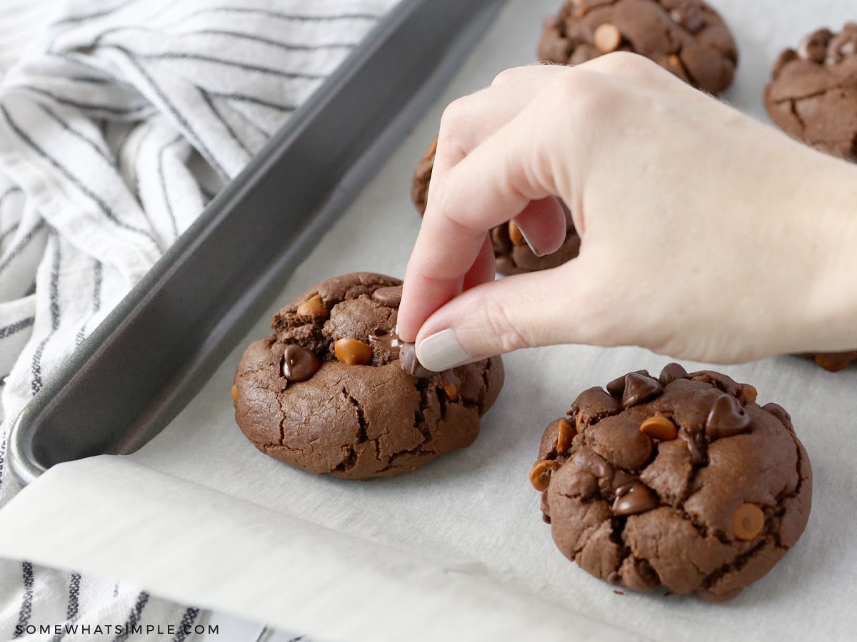 pressing cinnamon chips into cookies once they are baked