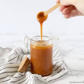 homemade salted caramel in a glass jar with wood spoon