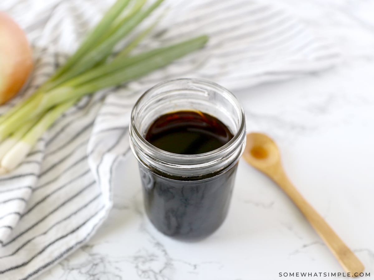 jar of teriyaki sauce on the counter next to a wooden spoon