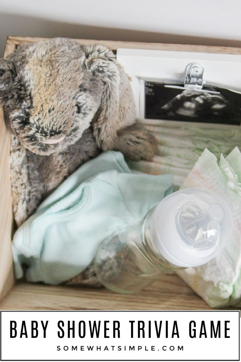 Baby Shower Gift in a basket with onesies, a stuffed bunny, and other baby items