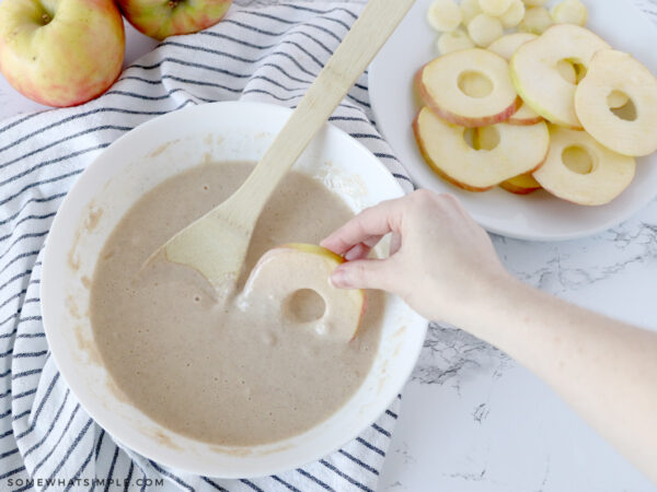 dipping the apple slices into batter