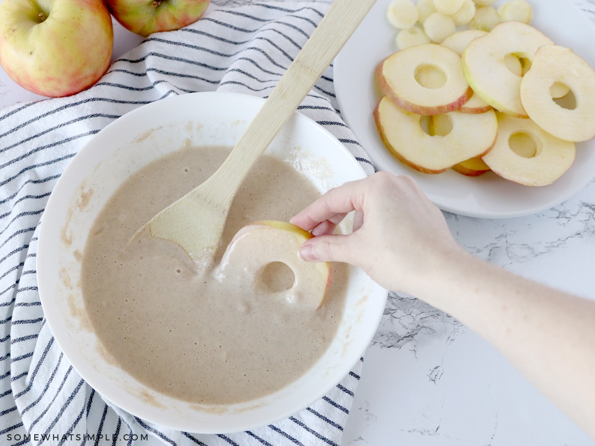 dipping the apple slices into batter