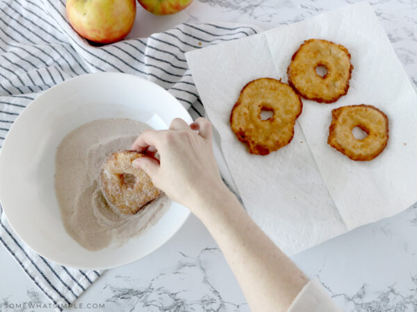 rolling the apple slices into a cinnamon sugar mixture